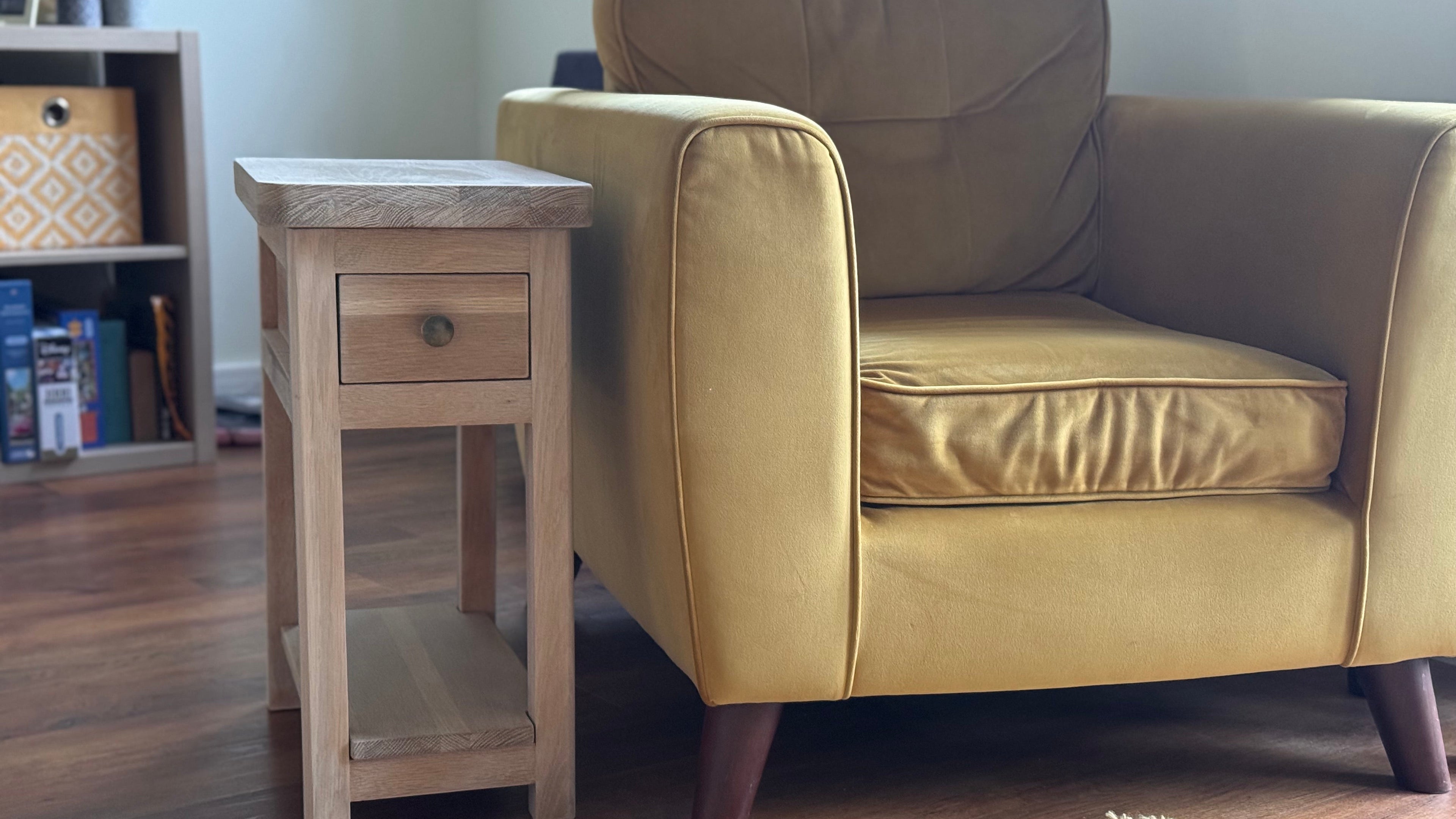 Solid oak side table beside an armchair